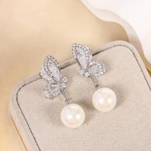 Detailed close-up view of elegant butterfly earrings with sparkling crystals and pearls