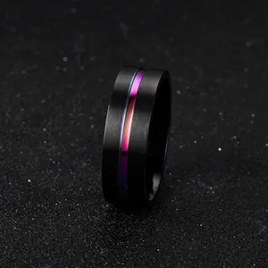 Close-up of black stainless steel ring with a colorful gradient stripe on black background
