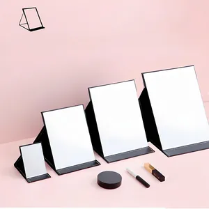 Detailed view of four different sizes of portable folding makeup mirrors with leather cover