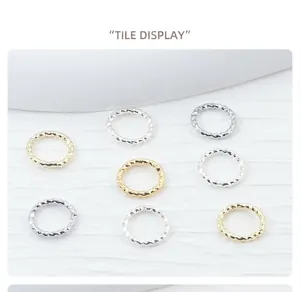 Macro detail of 14K gold filled and silver plated twisted texture jump rings for DIY jewelry.