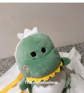 Detailed view of a cute green plush dinosaur crossbody bag with a white crown