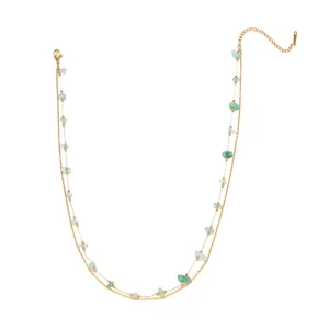 Detailed view of a double-layered gold chain necklace with green natural stone beads