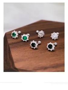 Close-up of S999 silver screw-back stud earrings with colorful flower-shaped stones.