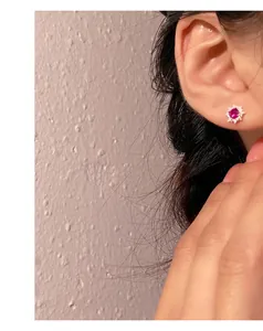 Detailed view of an elegant S999 sterling silver stud earring with a pink gemstone on ear