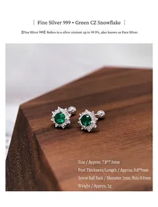 Detail view of S999 silver snowflake earrings with green zircon and screw back closure.