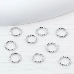 Set of silver twisted jump rings for DIY jewelry making and bracelet connecting.