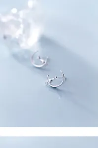 Detailed close-up of S925 silver stud earrings with a cat sitting on a crescent moon