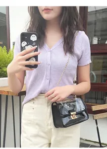 Primo piano di una borsa a tracolla in gelatina trasparente con catena d'oro e fibbia