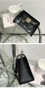 Dettagli di una borsa a tracolla jelly trasparente con pochette nera e catena d'oro