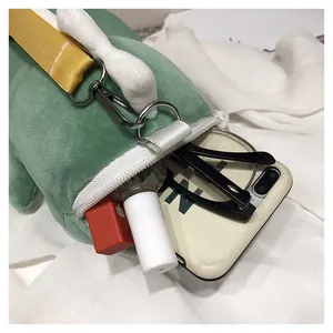Detail view of cute plush dinosaur crossbody bag showing interior storage capacity