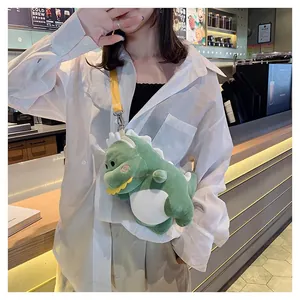 Detailed lifestyle shot of a cute green dinosaur plush crossbody bag worn with a white linen shirt.