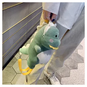 Cute green plush dinosaur crossbody bag held by a person showing its soft texture.