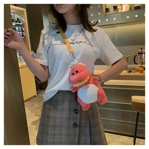 Detailed view showing a cute pink plush dinosaur crossbody bag worn by a female model