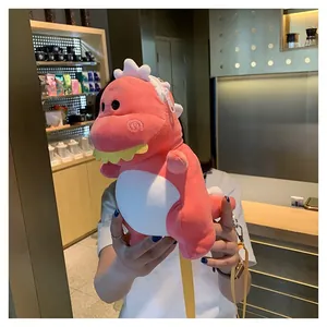 Cute pink plush dinosaur crossbody bag held in hands to show scale and soft texture