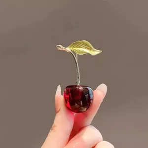 Elegant cherry-shaped brooch with dark red resin fruit and golden metal leaf details