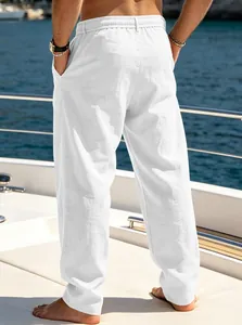 Detailed back view of men's white loose breathable linen pants for beach vacation on a yacht