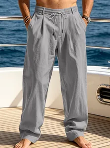 Detail view of men's loose grey linen-style trousers on a boat deck