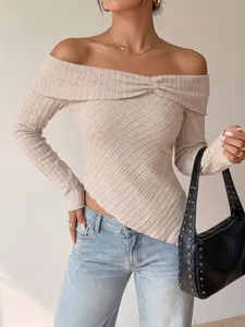 Detail view of a beige off-shoulder ribbed knit top featuring an asymmetrical hem and soft texture