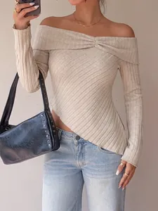 Detail of the textured knit pattern on the beige off-the-shoulder asymmetrical top.