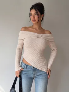 Detailed view of women's beige off-the-shoulder textured knit top with asymmetrical hem.