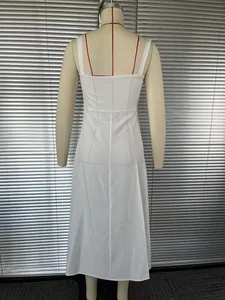 Back view detail of a minimalist white spaghetti strap maxi dress with a long slit.