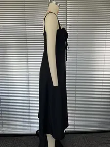 Detailed side view of elegant black French style camisole midi dress with slit on mannequin