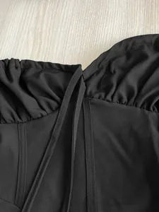 Detailed view of black French-style camisole dress with elegant ruching and seam detail