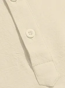 Close-up of beige cotton linen shirt showing intricate fabric texture and button detail