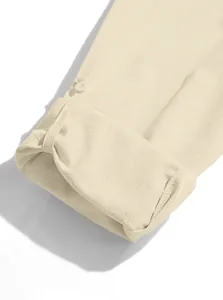 Close-up detail of beige cotton linen shirt cuff with button strap and fabric texture