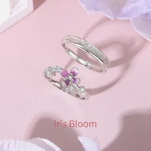 Anelli di coppia iris in argento con smalto viola e accenti di zirconi su sfondo rosa