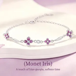 Elegante bracciale in argento con fiori viola e dettagli di foglie in primo piano.