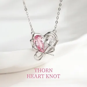 Dettaglio di ciondolo a cuore in argento con cristalli rosa e bianchi su catena