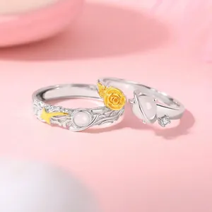 Primo piano di anelli di coppia stella e rosa con pietre di vetro bianco e accenti dorati.