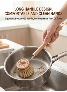 Ergonomic long-handled beech wood kitchen brush cleaning a stainless steel pot.