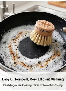 Detail shot of a wooden beech dish brush scrubbing a frying pan with soapy foam