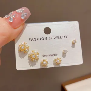 Close-up of six Korean style pearl and crystal stud earrings on white card