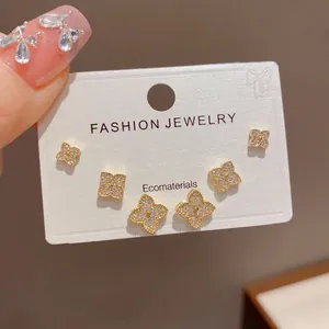 Close-up of gold-plated clover stud earring set with shimmering cubic zirconia