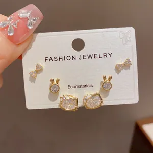 Detailed view of 3-pair earring set featuring bow, rabbit, and crystal cat head studs.