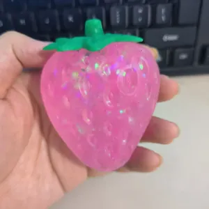 Sparkly pink glitter strawberry squishy toy for stress relief and slow rebound play