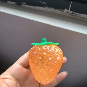 Detail of orange glitter strawberry squeeze toy with slow rebound soft gel texture