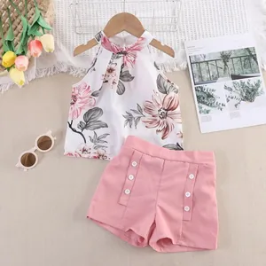 Dettaglio dell'outfit estivo per bambina con top floreale e pantaloncini rosa.