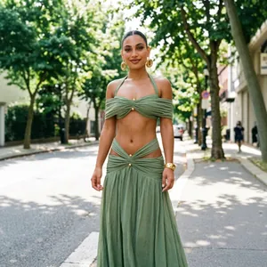 Elegante groene tweedelige set met off-shoulder top en lange rok met modieuze uitsneden.