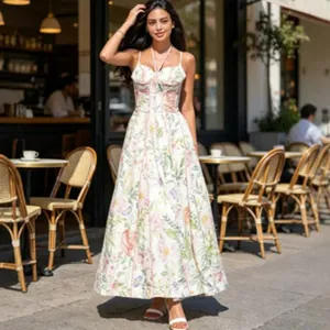 Robe longue élégante à imprimé fleuri avec corsage et fines bretelles dans un café