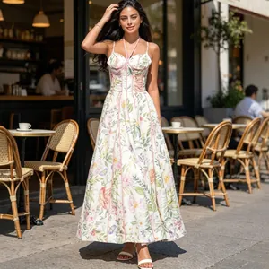 Elegante maxi-jurk met bloemenprint, korsetlijfje en spaghettibandjes in een café