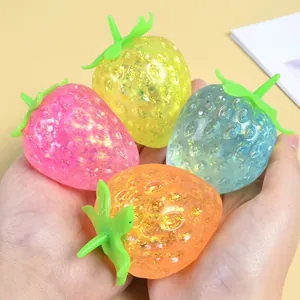 Close-up detail of four colorful glitter strawberry squishy toys for stress relief
