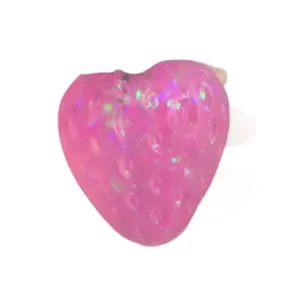 Macro detail of a pink translucent strawberry squishy toy with colorful glitter flakes
