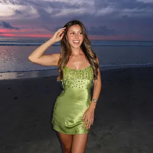 Sexy groene strapless jurk met pailletten borduursel gestyled op een strand bij zonsondergang