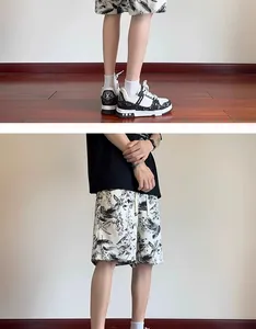 Detail view of men's quick-dry casual beach shorts with black ink-wash floral pattern