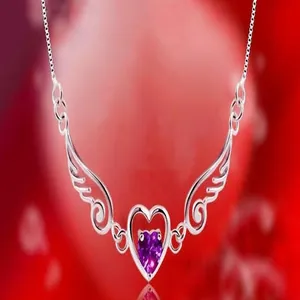 Close-up of a silver angel wing necklace featuring a purple heart-shaped stone