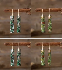 Detailed macro view showing green natural stone rectangular earrings on wooden branch
